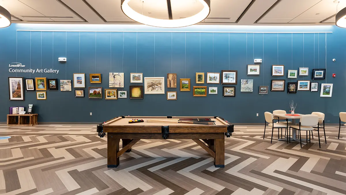 A room with a pool table and pictures on the wall.