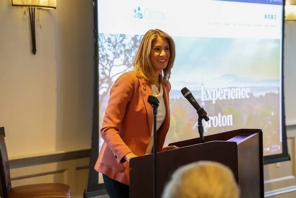 Woman speaking at a podium with microphone.