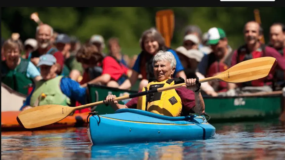 Woman kayaking with a wooden paddle.